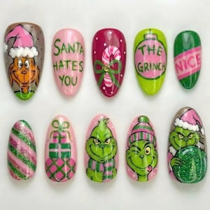 May include: A set of ten artificial nails with Christmas-themed designs. The designs include the Grinch, Santa hats, candy canes, and the phrases "Santa Hates You" and "Nice". The nails are painted in various colours, including green, pink, and red.