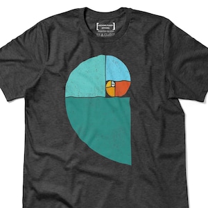 May include: Dark gray t-shirt featuring a colorful graphic of the golden ratio spiral. The design includes teal, blue, orange, and yellow sections. The shirt has a crew neck and short sleeves. The text "HECKING FUNNY APPAREL PRINTED IN USA" is printed on the shirt.