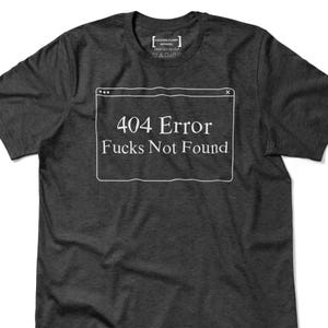 May include: Dark gray t-shirt with the text "404 Error Fucks Not Found" in a white box. The shirt also has a small logo at the top.