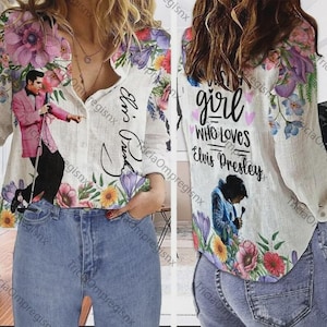 May include: White button-down shirt with floral and Elvis Presley graphics. The front features an image of Elvis in a pink suit, and the back says "A girl who loves Elvis Presley". The shirt is decorated with colorful flowers.