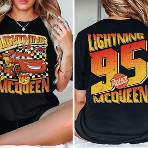 May include: Black t-shirt with a graphic of Lightning McQueen from the Cars film. The front design shows McQueen with the text "Lightning 95 McQueen". The back of the shirt features "Lightning 95 McQueen" in orange and yellow.