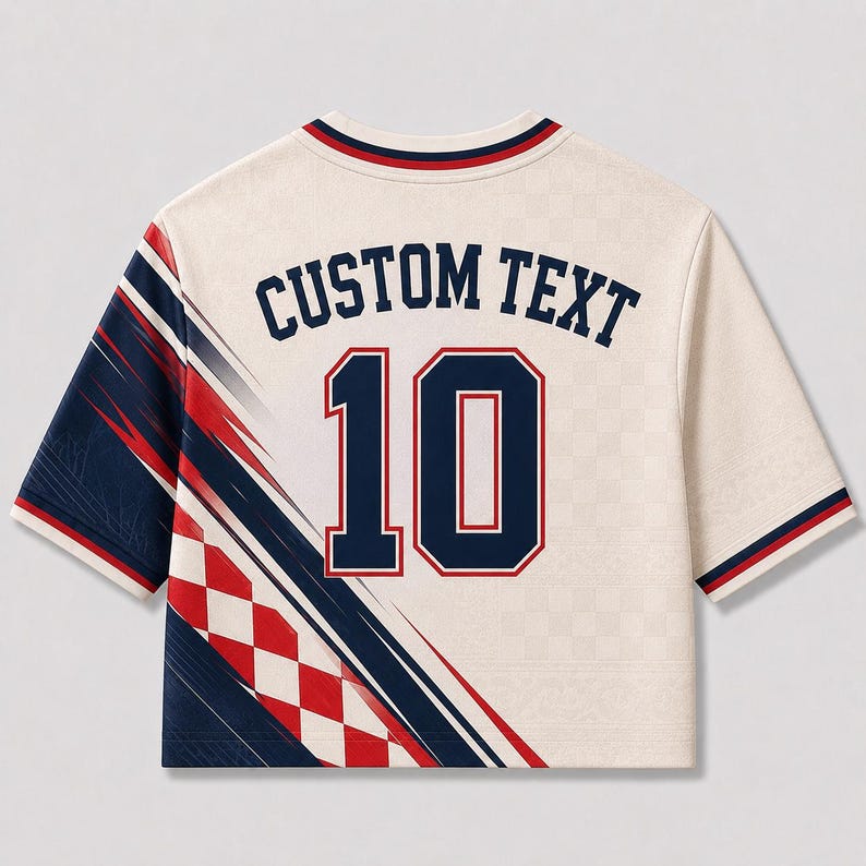 Puede incluir: Una camiseta de manga corta color crema con el texto CUSTOM TEXT sobre el n&uacute;mero 10 en azul marino con bordes rojos. El lado izquierdo muestra un patr&oacute;n diagonal de rayas azul marino, l&iacute;neas rojas y un dise&ntilde;o de cuadros rojos y blancos.