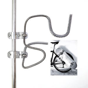 Puede incluir: Un soporte de varilla corrugada plateada diseñado para montarse en un poste vertical, con dos brazos curvos para sujetar un monopatín. Una imagen insertada muestra el soporte fijado al cuadro de una bicicleta, sosteniendo un monopatín.