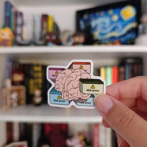 May include: A sticker depicting a brain graphic overlaid with computer windows, each showing a "404 error" message. The design uses pastel colours and includes warning symbols on the windows.