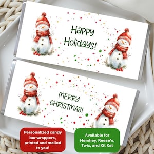 May include: Two rectangular candy bar wrappers with white backgrounds featuring watercolor snowmen wearing red hats and scarves. The top wrapper says Happy Holidays! and the bottom says MERRY CHRISTMAS! with red and green confetti dots.