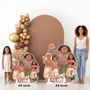 May include: Cardboard cutouts of characters from the animated film Moana, including Maui, Moana, and others, are displayed. The cutouts are 35 and 45 inches tall. A balloon arch and a brown arch are in the background.
