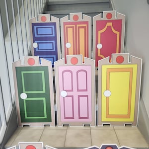 May include: A collection of colorful, cartoon-style door cutouts. Each door features a unique design and color scheme, including blue, orange, red, green, pink, and yellow. The doors are arranged on a staircase, suggesting a decorative or themed display.