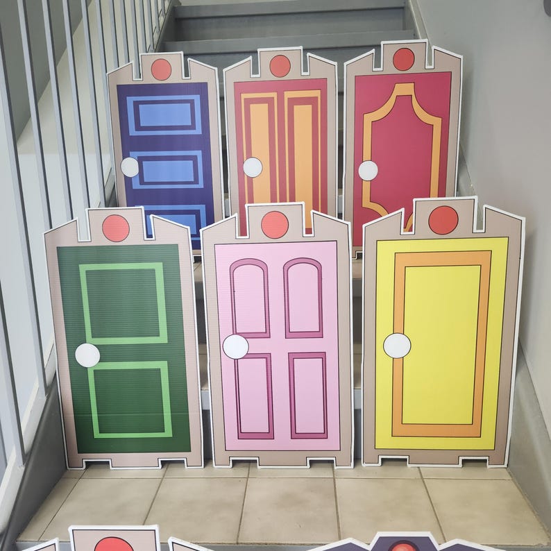 May include: A collection of colorful, cartoon-style door cutouts. Each door features a unique design and color scheme, including blue, orange, red, green, pink, and yellow. The doors are arranged on a staircase, suggesting a decorative or themed display.