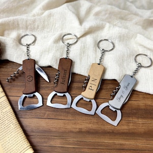 May include: A white ceramic mug with a black handle and the text "But First, Coffee" in a bold, black font. The mug is set against a blurred background, suggesting a cozy setting.
