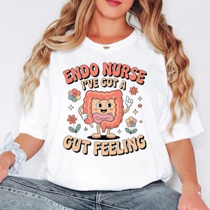 May include: White t-shirt with a retro design featuring the text "ENDO NURSE I'VE GOT A GUT FEELING". The design includes a cartoon illustration of an intestine with a smiling face, flowers, and stars.