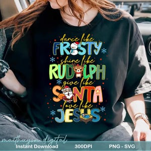 May include: Black t-shirt with colorful text and illustrations. The text reads "dance like FROSTY, shine like RUDOLPH, give like SANTA, love like JESUS." Includes images of a snowman, reindeer, Santa Claus, and baby Jesus. The words are in various colors.