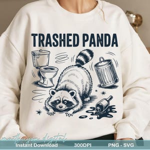 May include: Off-white sweatshirt featuring a raccoon illustration with the text "Trashed Panda." The design includes a toilet, a tipped-over bin, and a spilled bottle. The artwork is in black and white.