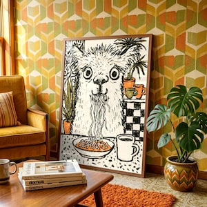 May include: A framed wall art print featuring a black and white line drawing of a llama eating a bowl of noodles. The llama is positioned behind a table with a bowl of pasta and a mug. The illustration style uses bold, expressive ink strokes.