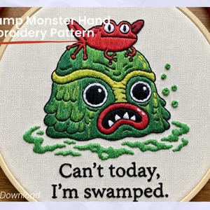 Pode incluir: Bordado de um monstro do pântano verde com uma rã vermelha no topo, num bastidor de madeira. O texto diz: "Can't today, I'm swamped." (Hoje não posso, estou atolado). O desenho está num tecido creme.