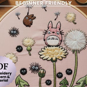 Könnte beinhalten: Gestickte Stickrahmenkunst mit rosa Hintergrund, die eine Zeichentrickfigur, Löwenzahnpflanzen und andere skurrile Elemente zeigt. Der Text "BEGINNER FRIENDLY" steht oben. Der Text "PDF Embroidery Pattern & Tutorial" steht unten.