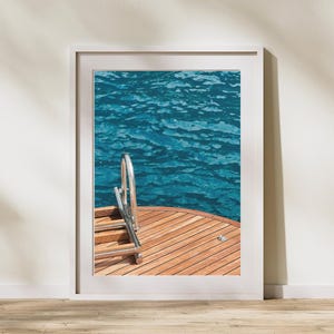 May include: Framed print showing a wooden boat deck with a stainless steel ladder descending into turquoise water. The water has a rippled texture, and the deck is made of light brown wood. The image is set in a white frame.