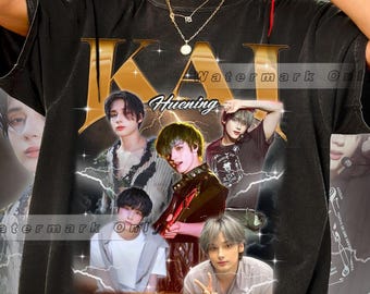 Puede incluir: Camiseta negra de gran tamaño con un collage de imágenes de un artista musical, con el nombre "KAI" en letras doradas en la parte superior. La palabra "Huening" está impresa debajo. La camiseta tiene un aspecto vintage y desgastado.