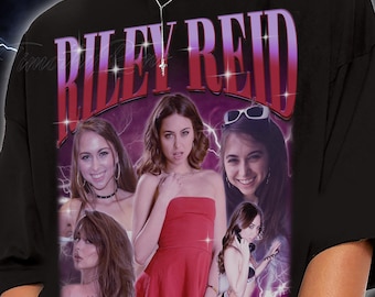 Puede incluir: Camiseta negra con un gráfico de Riley Reid en estilo retro. El diseño incorpora múltiples imágenes de Riley Reid, con el nombre "RILEY REID" en una fuente púrpura y roja.