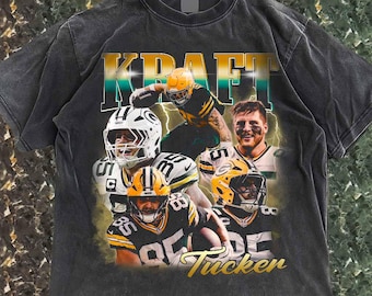 Puede incluir: Camiseta gris oscuro con un collage de jugadores de fútbol americano con uniformes verdes y amarillos. La camiseta tiene la palabra "KRAFT" en dorado y verde azulado, con el nombre "Tucker" en escritura dorada debajo.