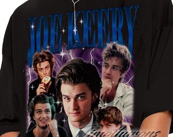 Puede incluir: Camiseta negra con un gráfico de Joe Keery y el texto "JOE KEERY" en azul. El diseño incluye múltiples imágenes del actor con un fondo de relámpagos morados y blancos. La camiseta tiene cuello redondo.