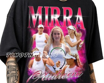 Puede incluir: Una camiseta negra con un estampado gráfico de la tenista Mirra Andreeva. El diseño incluye el texto "MIRRA" en letras rosas grandes en la parte superior, "Andreeva" en cursiva en la parte inferior y "TIMOTHIONS" al lado, con rayos rosas.