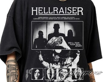Puede incluir: Camiseta negra con el título de la película "HELLRAISER" en letras blancas. El gráfico es una imagen en blanco y negro de personajes y el texto "WE'LL TEAR YOUR SOUL APART!". Los nombres de los actores están impresos debajo.