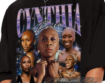 Puede incluir: Camiseta negra con un diseño gráfico que presenta múltiples imágenes de Cynthia Erivo. El diseño incluye el nombre "CYNTHIA" en fuente morada y blanca, con "Erivo" debajo. La camiseta tiene una estética vintage.
