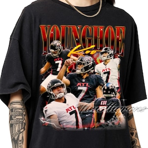 Puede incluir: Camiseta negra con un collage de un jugador de fútbol americano en acción, con el nombre "YOUNGHOE" en letras rojas y doradas. El jugador lleva un casco y una camiseta con el número 7 y "ATL".