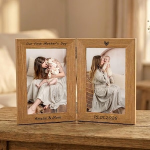 Pode incluir: Uma moldura de fotos de madeira de dois painéis com fotos de uma mãe e um bebê. A moldura é gravada com "Our First Mother's Day", "Amelia & Mom" e "15.01.2026". Um pequeno coração é gravado acima da foto direita.