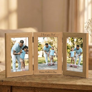 May include: A wooden tri-fold picture frame with three photos of a father and child. The center frame has the text "I love you Dad" and "Happy Father's Day". The frame is on a wooden table.