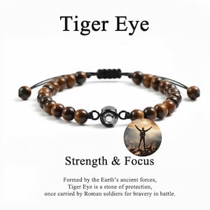 May include: A Tiger Eye beaded bracelet with brown and black beads. The bracelet has a black metal accent and is adjustable. The text "Tiger Eye" and "Strength & Focus" are displayed.