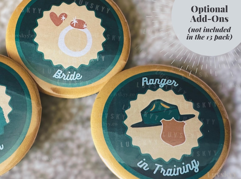 May include: Round wooden buttons with a dark green scalloped border and a tan center. One button features a white ring icon with a heart and the text Bride. Another button displays a green hat and brown badge with the text Ranger in Training.