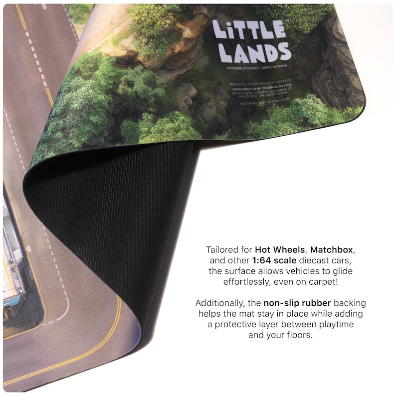 May include: A flexible play mat featuring a printed landscape with roads and green terrain, branded Little Lands. The mat has a black, textured non-slip rubber backing and is designed for 1:64 scale diecast cars. The surface shows a road layout.