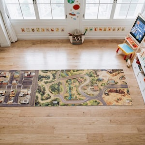 May include: A rectangular play mat featuring a printed design of a city grid on the left and a winding road through a natural landscape on the right. The mat is laid flat on a wooden floor, showcasing detailed illustrations of streets and terrain.