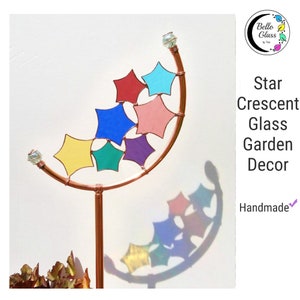 Peut inclure: Une d&eacute;coration de jardin en forme de croissant de lune en cuivre avec sept &eacute;toiles en verre de couleurs. Les &eacute;toiles sont rouges, bleues, jaunes, vertes, roses et violettes. La d&eacute;coration est faite &agrave; la main et comporte une perle de cristal au sommet.