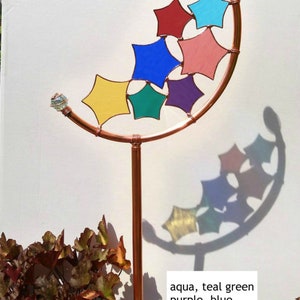 Peut inclure: Un piquet de jardin en cuivre avec un sommet incurv&eacute; et une s&eacute;rie d'&eacute;toiles en verre color&eacute;. Les &eacute;toiles sont de couleur aqua, vert sarcelle, violet, bleu, rose et jaune dor&eacute;. Le texte "aqua, teal green purple, blue grape, rose golden yellow" est &eacute;crit sous le piquet.