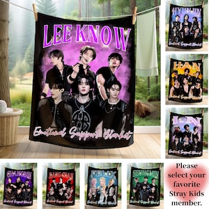 May include: Black blanket featuring a group of people with the text "LEE KNOW" in purple. The blanket also has the text "Emotional Support Blanket". Additional blankets with different names are also displayed.