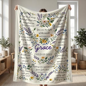 Può includere: Coperta color crema con disegni floreali e botanici e testo ispiratore. La parola "Grace" è centrata, circondata da una ghirlanda di fiori. I versetti biblici sono stampati sui bordi. Un elemento d'arredo per la casa accogliente e confortevole.