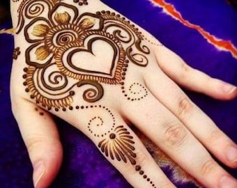 Könnte beinhalten: Nahaufnahme einer Hand, verziert mit aufwendiger Henna-Kunst. Das Design zeigt ein zentrales Herz, umgeben von floralen und wirbelnden Mustern in Brauntönen. Zarte Punkte und Linien erstrecken sich über die Finger und die Handfläche.