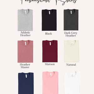 May include: A selection of nine t-shirts in various colors, including Athletic Heather, Black, Dark Grey Heather, Heather Mauve, Maroon, Natural, Navi, Pink, and White. The text "Farbauswahl T-Shirts" is at the top.