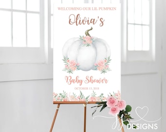 May include: A white pumpkin with pink flowers and greenery, with the text "Welcoming our lil pumpkin Olivia's Baby Shower October 13, 2018" on a white background.