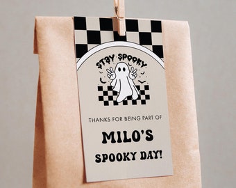 May include: A brown paper bag with a white tag attached. The tag has a black and white checkered pattern and a ghost illustration with the text "Stay Spooky". The tag also says "Thanks for being part of Milo's Spooky Day!"
