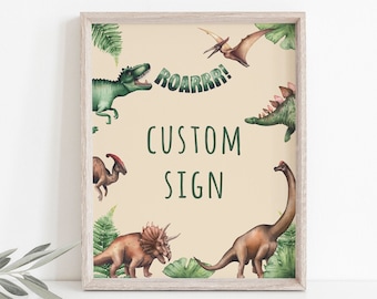 May include: A framed sign with a light beige background featuring watercolor illustrations of various dinosaurs and green foliage. The sign reads "ROARRR!" and "CUSTOM SIGN" in green text. The frame is a light wood color.