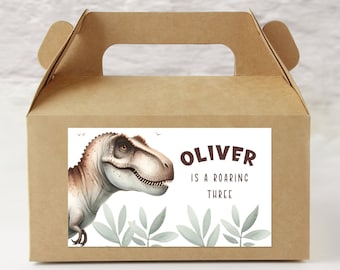 May include: A brown cardboard favor box with a sticker featuring a green dinosaur with the text "Oliver is a roaring three".