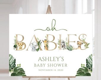 May include: A white welcome sign with gold lettering that reads "Oh Babies" with a green leafy design and animal illustrations. The sign also includes the text "Ashley's Baby Shower" and "November 14, 2020".