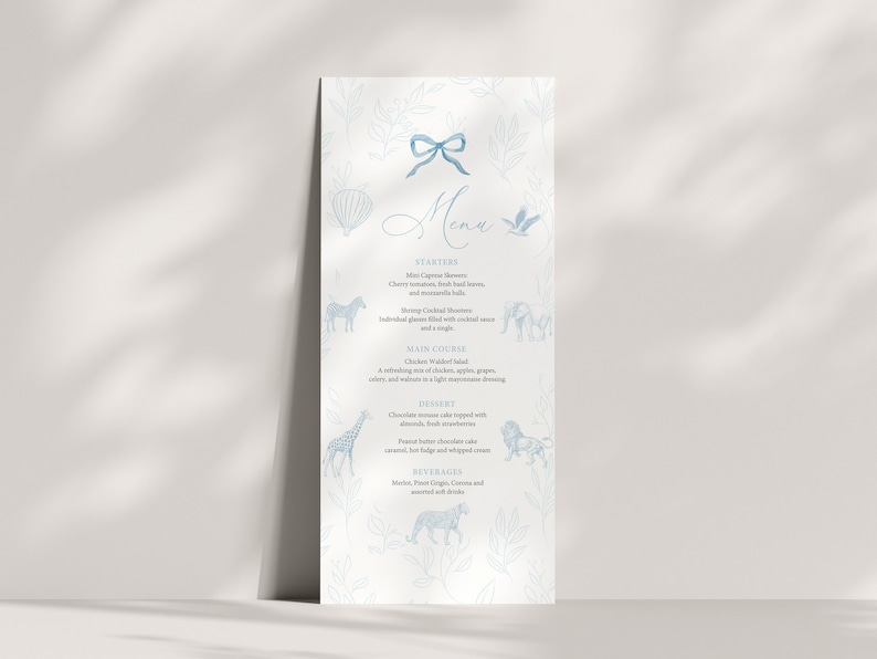 Peut inclure: Un menu bleu et blanc avec un n&oelig;ud bleu en haut. Le menu comprend des entr&eacute;es, un plat principal, un dessert et des boissons. Le menu est d&eacute;cor&eacute; d'illustrations d'animaux, dont un z&egrave;bre, un &eacute;l&eacute;phant, une girafe et un lion.