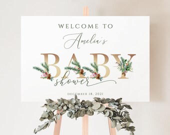 May include: Welcome to Amelia's Baby Shower sign with gold lettering and a wintery floral design. The sign says "Welcome to Amelia's Baby Shower" and "December 18, 2021".