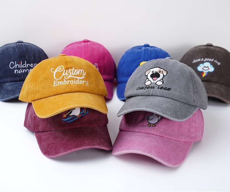 May include: A collection of colorful baseball caps in various shades, including yellow, blue, pink, and gray. Some caps feature embroidered designs and text, such as "Custom Embroidery," a dog logo, and "Children name."
