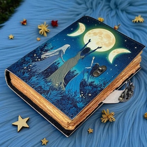 Puede incluir: Un diario encuadernado en cuero con un dise&ntilde;o celestial. La portada presenta una escena nocturna con tres figuras que se extienden hacia una luna llena y medias lunas. El diario tiene un cierre de metal y p&aacute;ginas envejecidas. Estrellas y flores decorativas rodean el diario.