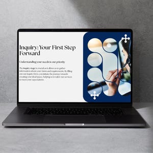 May include: A laptop displaying a webpage with the text "Inquiry: Your First Step Forward." The screen has a white background with text and a blue design on the right side. The laptop is on a gray surface.